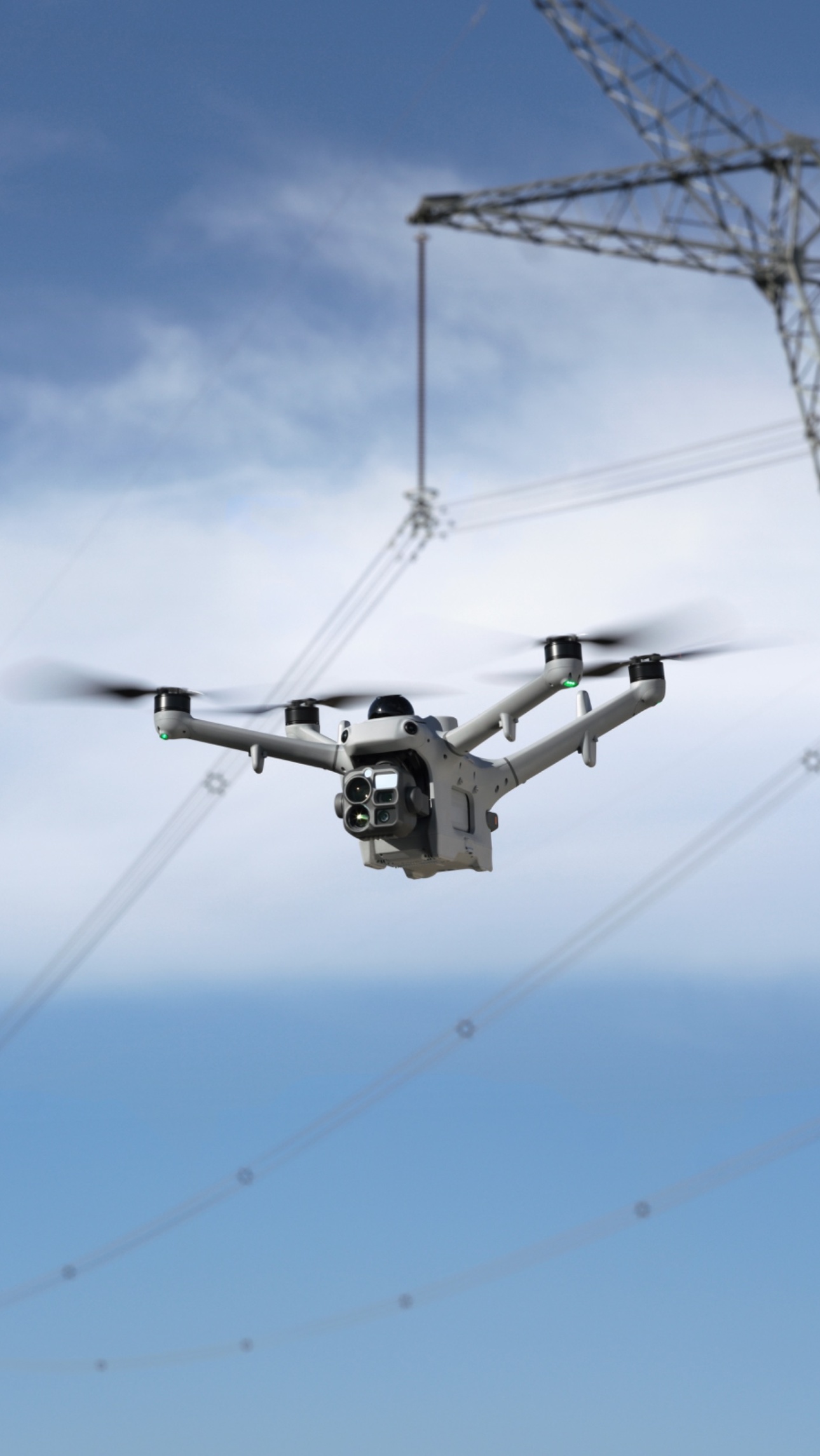 DJI Matrice 5TD flying beside a high-voltage transmission tower, from official DJI Dock 4 imagery.