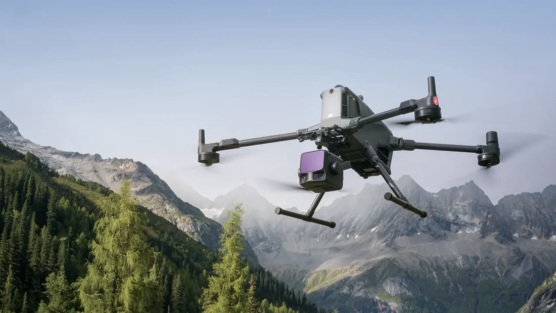 DJI Matrice 400 carrying a Zenmuse L3 LiDAR payload in flight over a Canadian corridor at dusk.