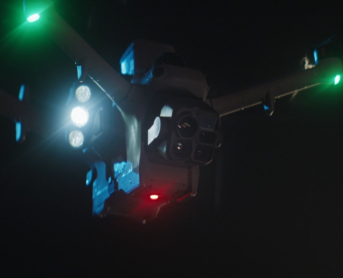 DJI enterprise drone flying at night with its lights on, from official DJI Dock 4 imagery.