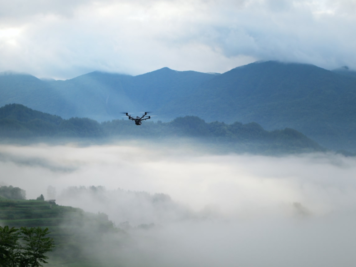 DJI enterprise drone flying over a fog-covered valley, from official DJI Dock 4 imagery.