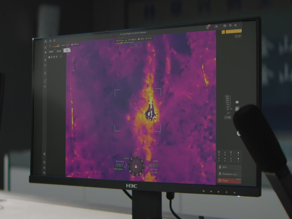 DJI radiometric thermal feed showing a heat source and temperature readings on an operations monitor.