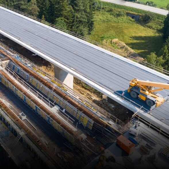Aerial view captured by a DJI Matrice 4 Series drone of an elevated highway construction site with cranes and active civil works.