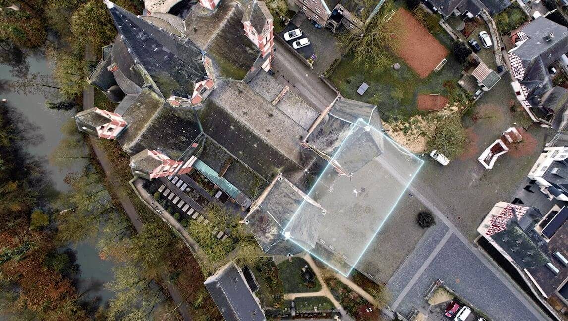 High-resolution drone orthomosaic of a building and its surrounding site with a capture boundary overlaid.