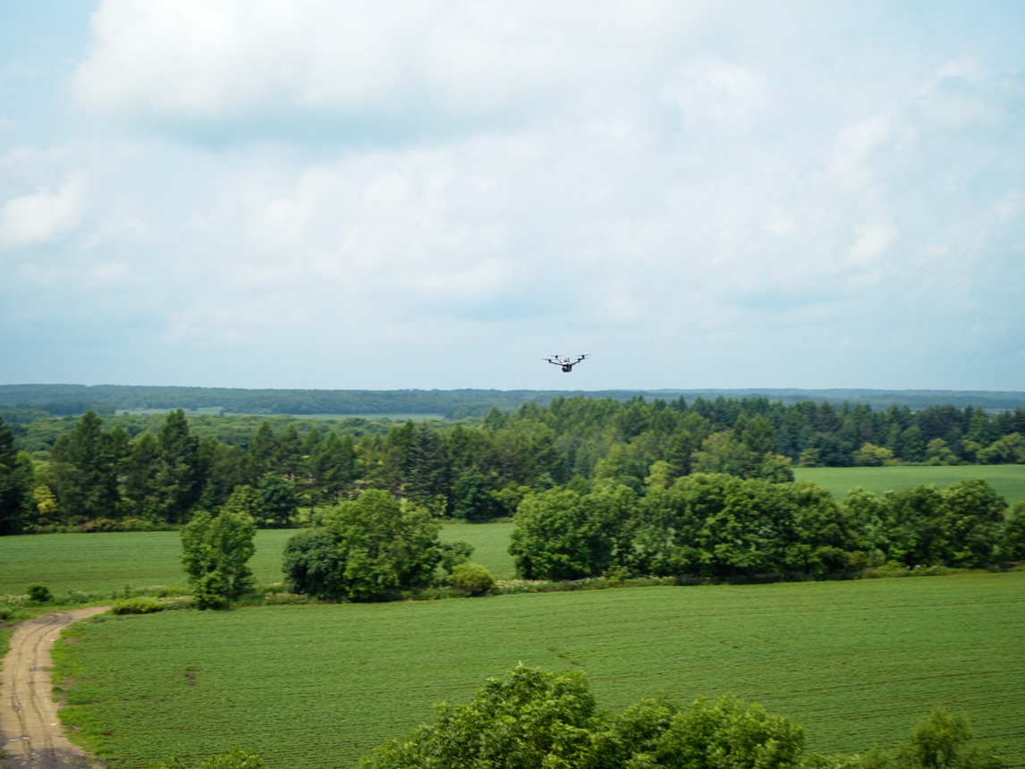 DJI enterprise drone flying over open countryside and tree lines, from official DJI Dock 4 imagery.