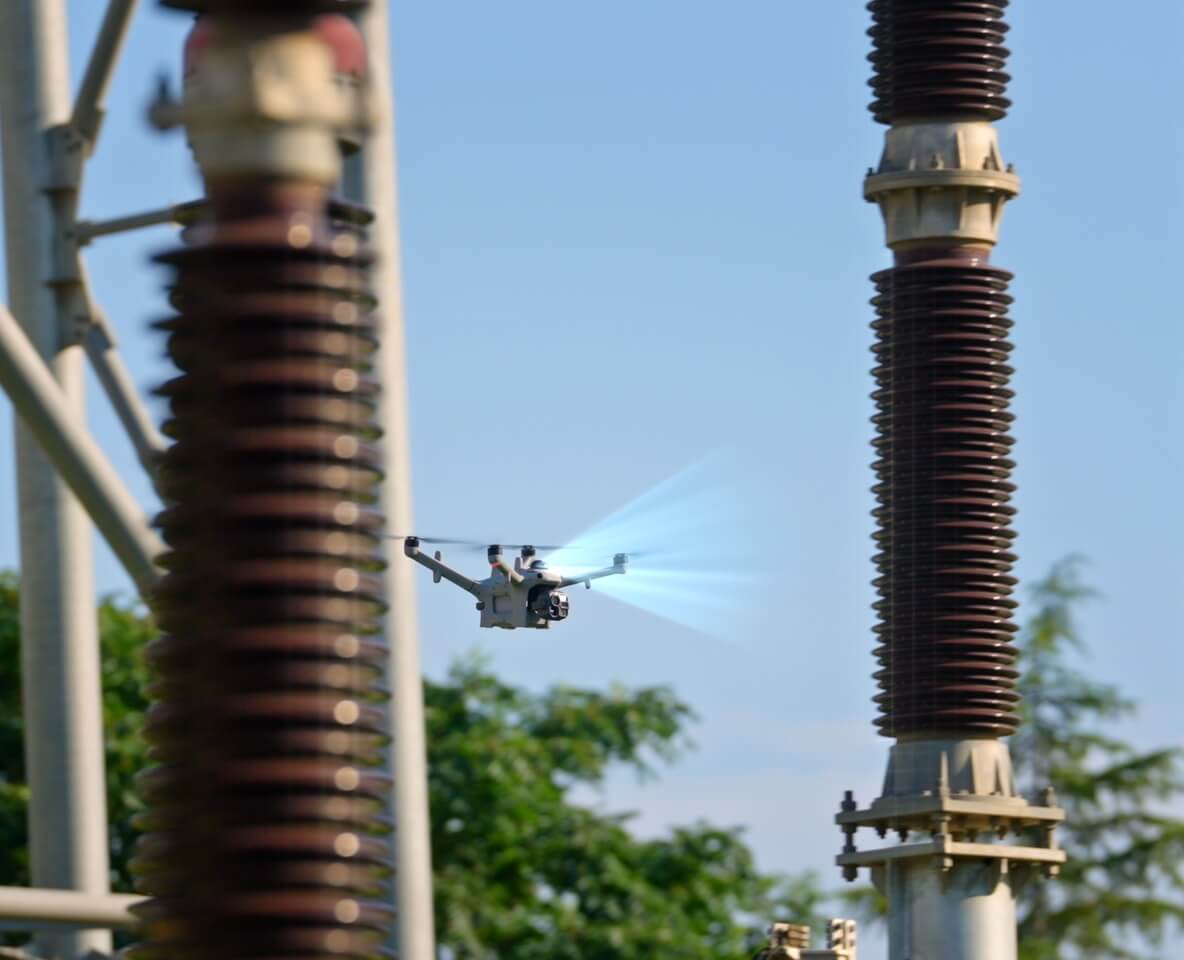 DJI Matrice 5TD inspecting electrical equipment between substation insulators; original DJI visualization.