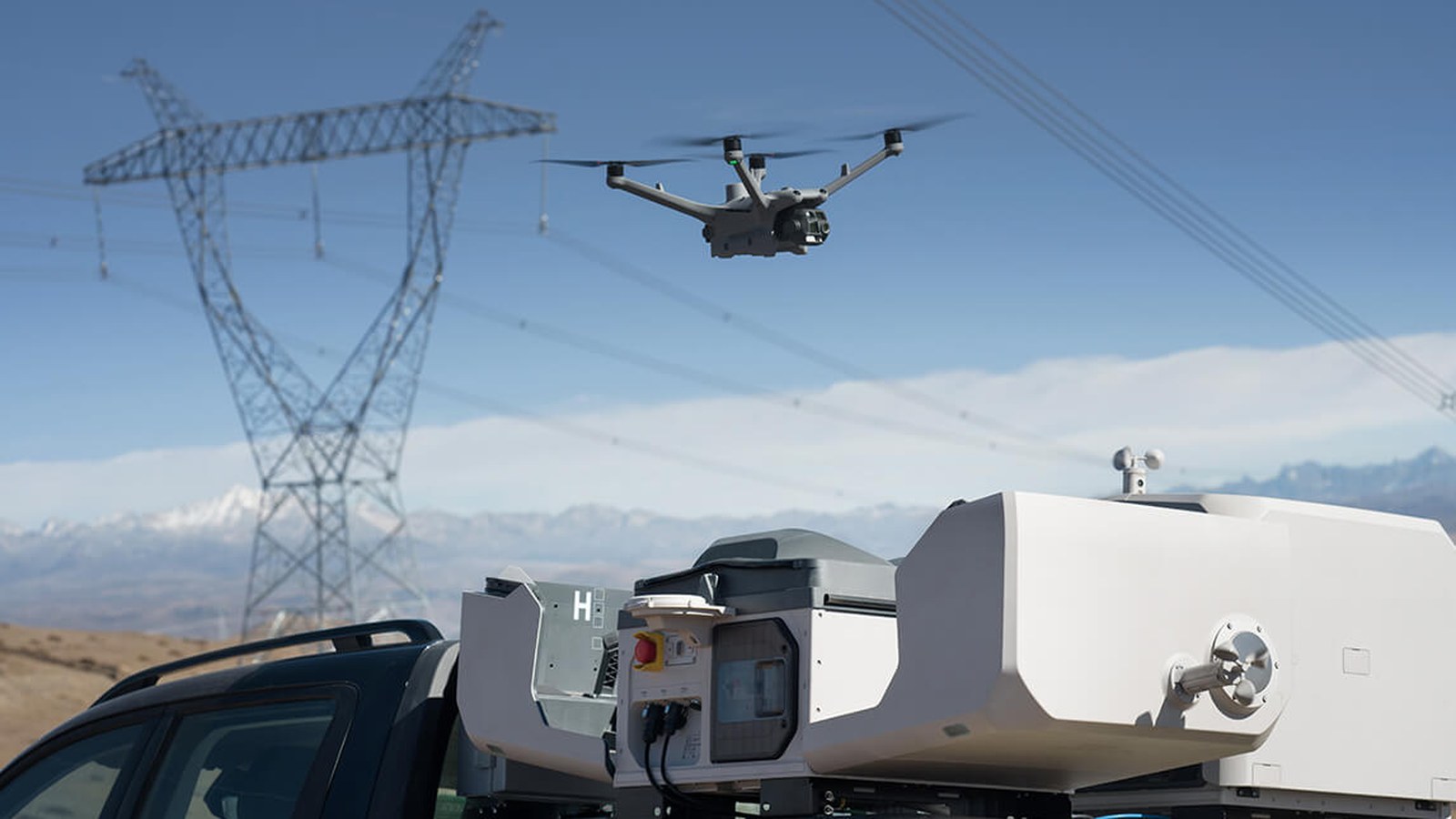 DJI Matrice drone flying above a vehicle-mounted DJI Dock 3 utility inspection system.